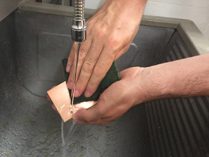 Cleaning the PCB with an abrasive pad, some soap and water. (click to enlarge)