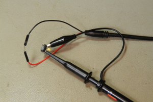 A small ferrite 2.56uH inductor and a ceramic 448 pF capacitor being tested with the ring-down method. The square wave generator is connected to the loop and the oscilloscope is in parallel via a 10:1 probe (click to enlarge).